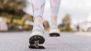 A close-up of a person’s running shoes in motion on an outdoor path, symbolizing the role of movement and NEAT (non-exercise activity thermogenesis) in boosting metabolism.