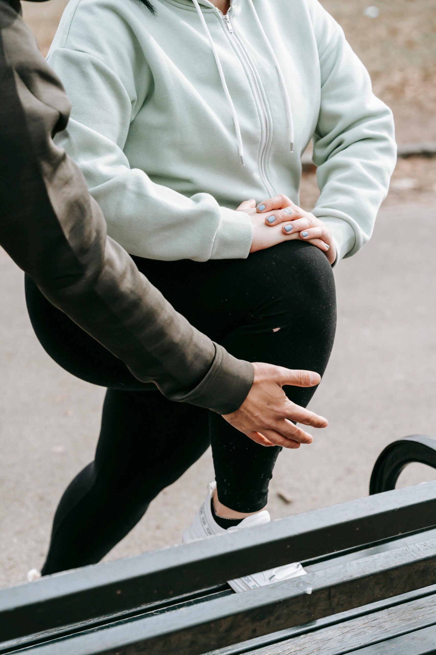 A person struggling with leg pain while climbing stairs, representing mobility issues linked to genetic obesity and excess weight.