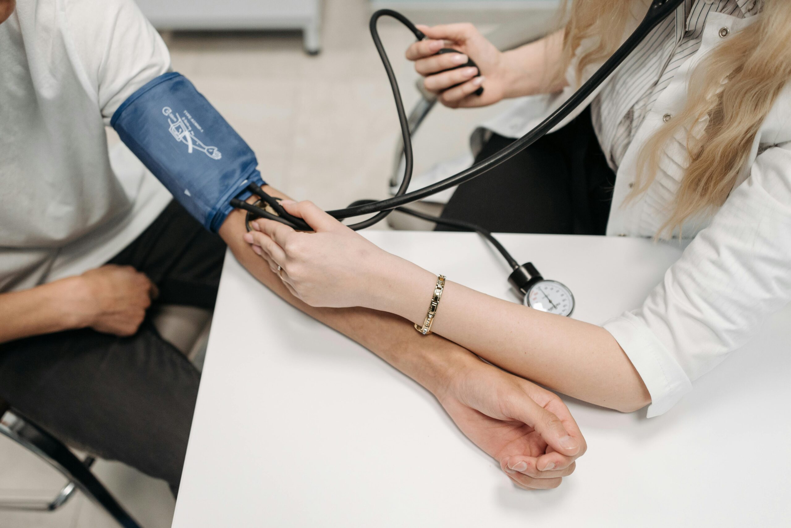 A healthcare professional measuring a patient’s blood pressure, representing the impact of lifestyle and exercise on hypertension management.
